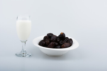 Isolated dates with milk in a plate 