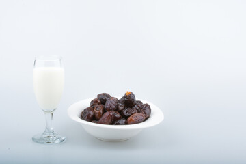 Isolated dates with milk in a plate 
