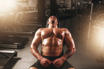 Fototapeta na wymiar Male bodybuilder training with dumbbells in gym