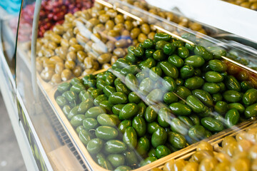 Eco-friendly products on a market stall . Different varieties of pickled olives