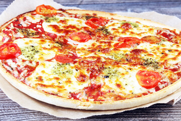Hot true ITALIAN PIZZA with basil and cheese. TOP VIEW Tasty traditional pepperoni pizza on board on wooden table with decoration