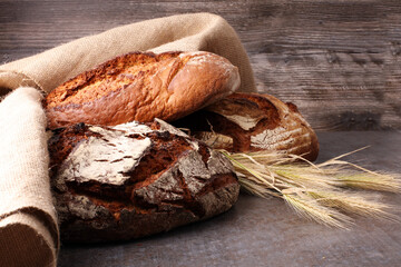 Different kinds of bread and bread rolls on board from above. Kitchen or bakery poster design.