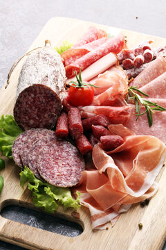 Food tray with delicious salami, pieces of sliced ham, sausage,
