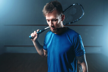 Squash player with racket, indoor training court