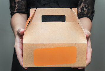 A woman in black dress stood bringing a snack box