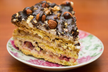 Piece of cake with hazelnuts and chocolate - in a saucer