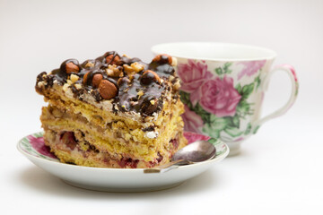 Piece of cake with hazelnuts, teaspoon and cup