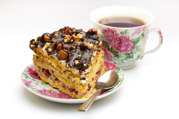 Piece of cake with hazelnuts, teaspoon and cup