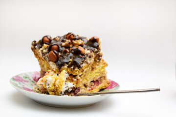 Piece of cake with hazelnuts and chocolate in a saucer