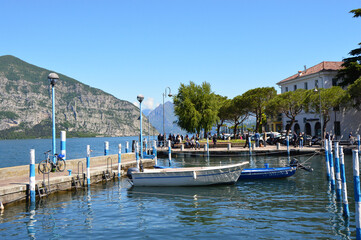 Fototapeta na wymiar ISEO, ITALY - MAY 13, 2017: View of the pier of Iseo Lake with boats, Iseo, Italy