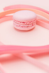 Pink Macaron and paper strips on a light background