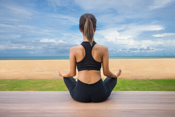 Asian young woman practicing yoga in morning, Asian woman is practicing yoga on the beach