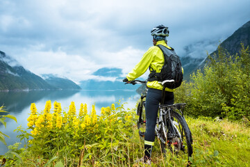 Mountain bike cyclist near fjord, Norway