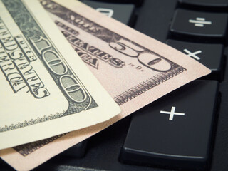 Banknotes of American dollars are on a calculator
