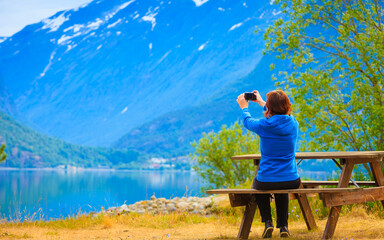 Fototapeta na wymiar Tourist taking photo at norwegian fjord