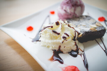 Homemade brownies with vanilla ice cream and whipped cream.(selective focus)
