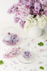 Tea from lilac flowers on white background