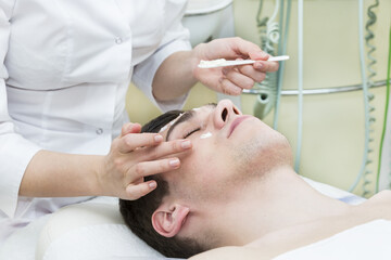 Obraz na płótnie Canvas Man in the mask cosmetic procedure in spa salon 