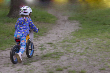 Toddler in helmet on bike in park