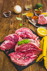 Fresh and raw meat. Still life of red meat steak ready to cook on the barbecue. Black slate background