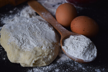 flour and bakery ingredients on black background