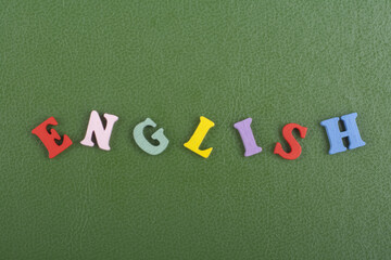 English word on green background composed from colorful abc alphabet block wooden letters, copy space for ad text. Learning english concept.