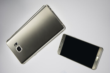 Modern smartphone. Isolated on white background. Two different positions. Blank screen for mockup. Showing back and the front of the phone.