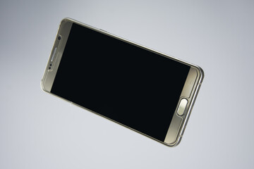 Modern smartphone. Isolated on white background. Showing the front of the phone. Blank screen for mockup.