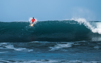 Surfer passing big ocean wave