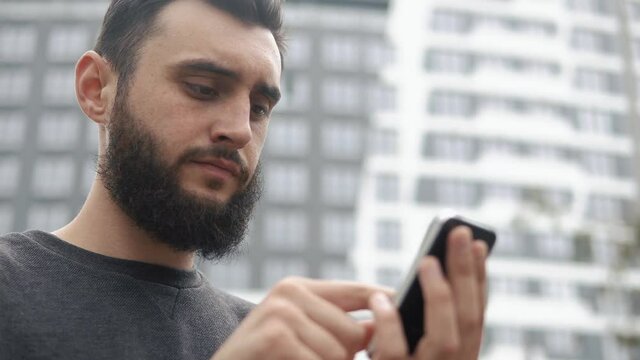 Man types something on his smartphone
