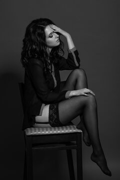 Black and white photo of a young seductive brunette woman in studio. Sexy woman in black lingerie. Monochrome image.