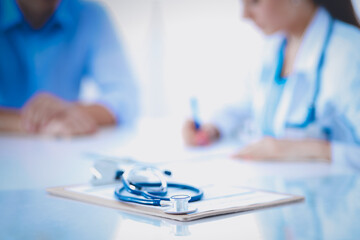 Doctor woman sitting with male patient at the desk