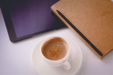 Empty tablet and a cup of coffee on the desk
