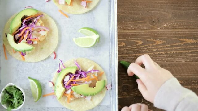 Fresh fish tacos with cod and purple cabbage on a white corn tortillas