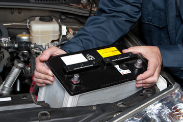 Fototapeta Auto mechanic replacing car battery obraz