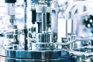 Steel pipes on the body of the pharmaceutical reactor, photo close-up, selective focus.