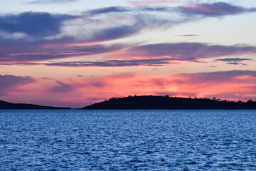 Sunset on the blue sea with clouds.  Sunset with orange, purple and gray clouds.