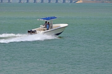 Fototapeta premium Small fishing boat p;owe red by two outboard engines speeding across the florida intra-coastal waterway off Miami Beach,