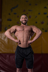 Fototapeta na wymiar Muscular Body Builder Showing His Front Lat Spread