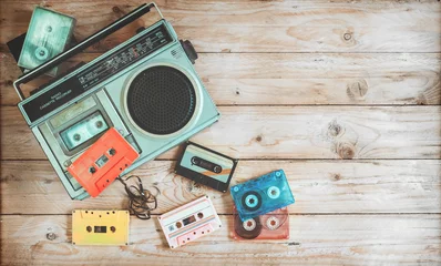 Tuinposter Bovenaanzicht held header - retro technologie van radio cassetterecorder muziek met retro tape cassette op houten tafel. Vintage kleureffectstijlen. © jakkapan