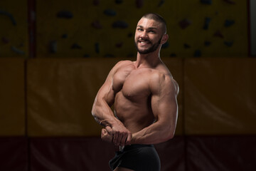 Fototapeta na wymiar Muscular Bodybuilder Showing His Side Chest