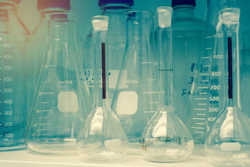 Laboratory glassware or beakers in cold and vintage tone stack on shelf, science research,science concept	