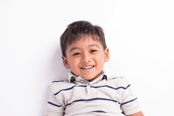 close up of cute asian boy smile and lying on floor