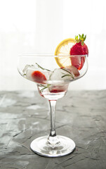 cocktail made from Strawberries and rosemary ice cubes into the glass
