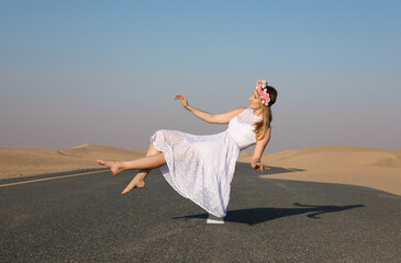 Young beautiful girl with blonde hair and flower crown floating in the air in the desert.