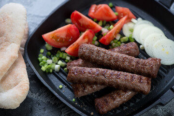 Closeup of grilled balkan traditional cevapi or cevapcici sausages, studio shot, selective focus