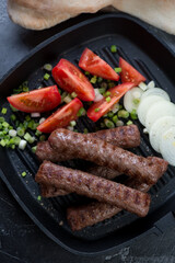 Barbecued balkan cevapi or cevapcici, high angle view, close-up, vertical shot