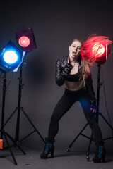 Girl in a leather jacket on stage and colored spotlights