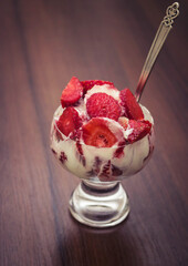 Sliced strawberries with cream in a glass