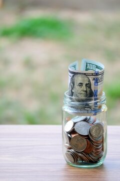 Dollar coin and banknote cash saving in glass jar, finance saving concept
